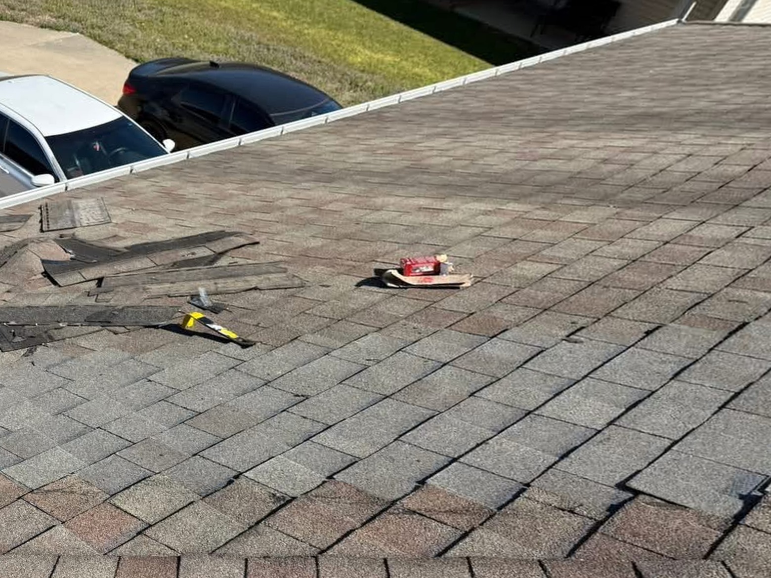 Repaired roof section with new shingles blended into the surrounding roof