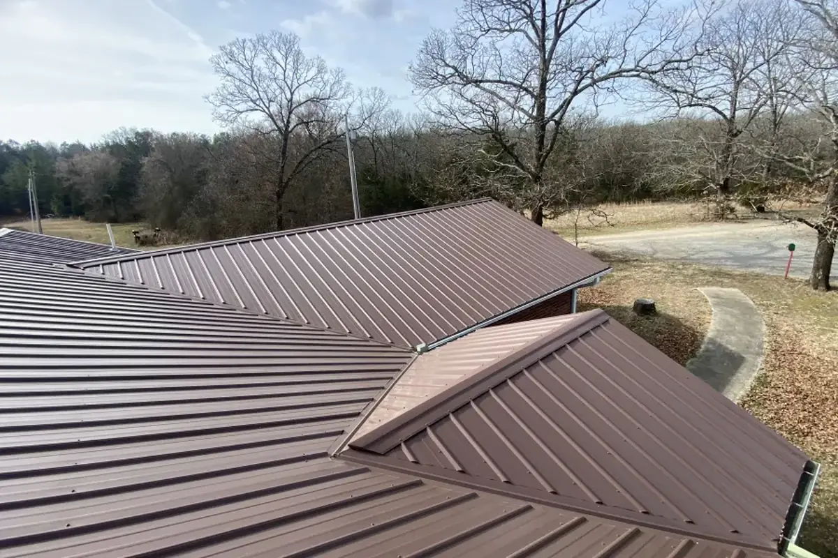 Brown ribbed metal roof with exposed-fastener panels running from ridge to eave