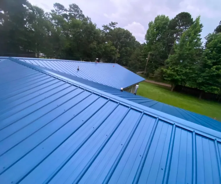Blue ribbed metal roof with exposed-fastener panels running down the slope