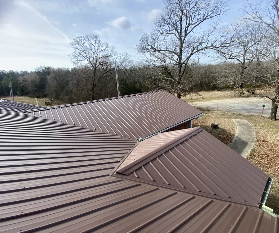 Brown ribbed metal roof with exposed-fastener panels running from ridge to eave