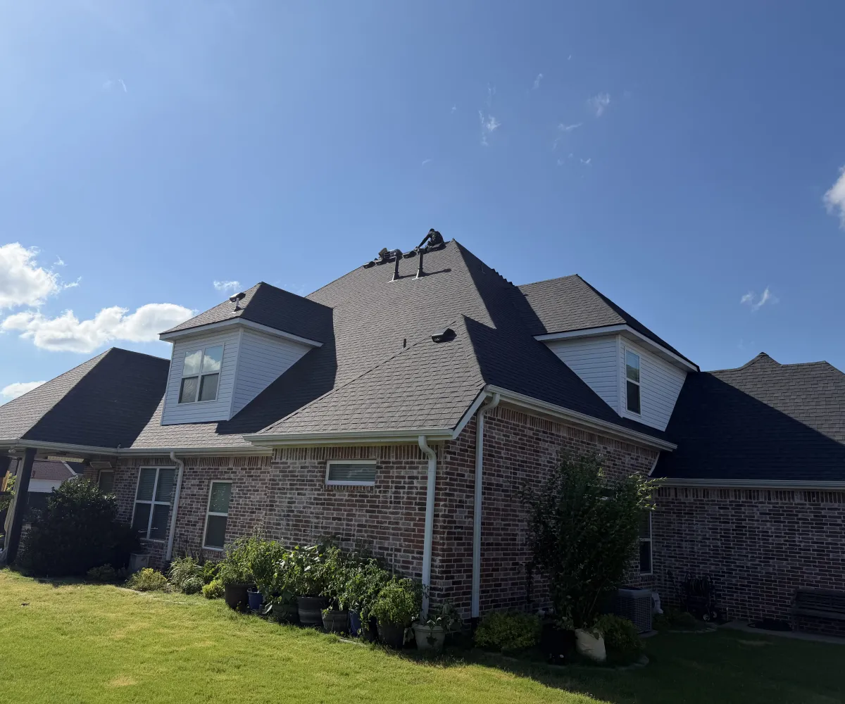 Large two-storey brick home with a new TAMKO Titan XT Rustic Black architectural shingle roof